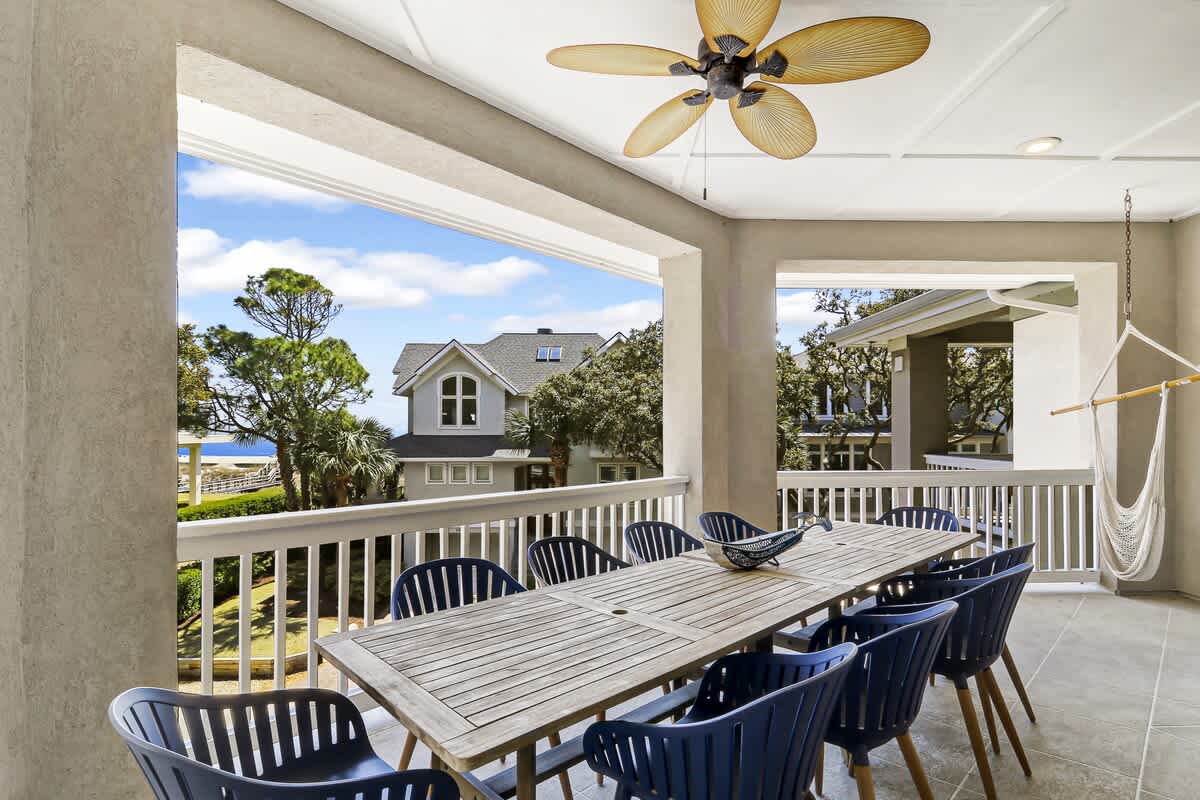 Gather around your spacious covered dining area with sweeping neighborhood views, perfect for memorable meals under the gentle breeze of the tropical ceiling fan.