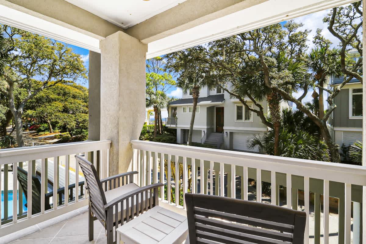 Step onto your private balcony where morning coffee feels magical among swaying palms and peaceful neighborhood views.