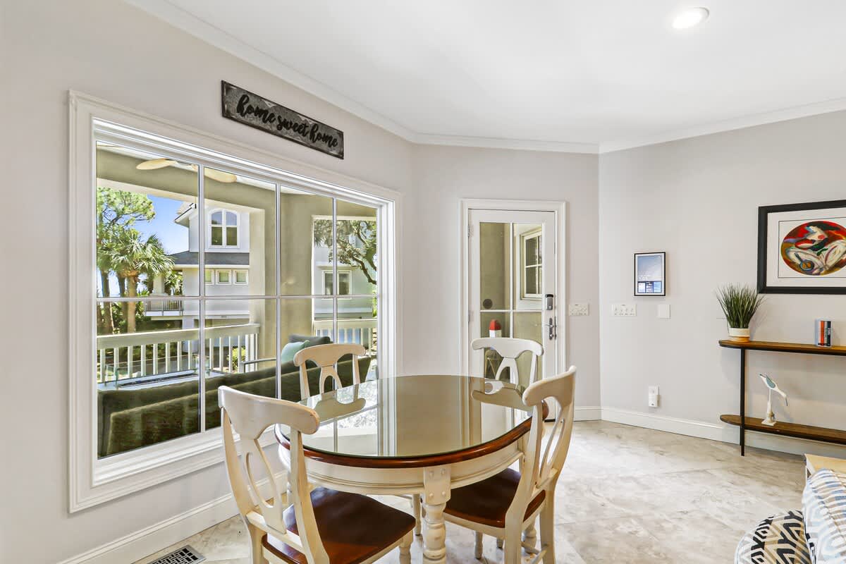 Your bright dining area opens to a charming balcony where morning coffee tastes better with neighborhood views and gentle breezes.