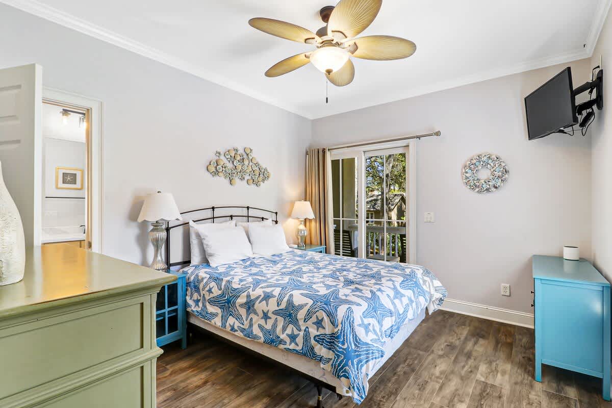 Drift off to sleep in your coastal-themed bedroom, where tropical ceiling fans and French doors create a peaceful retreat.