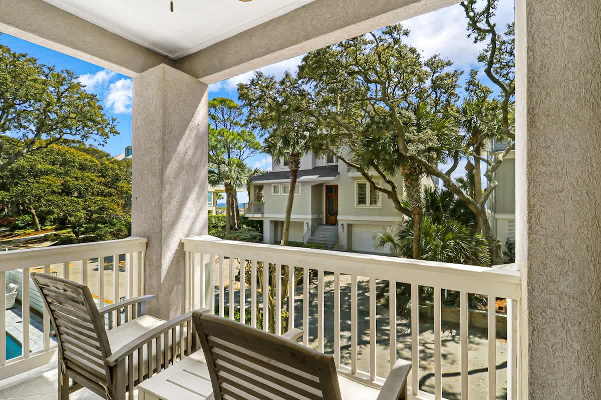 Step onto your shared balcony and breathe in the fresh coastal air while enjoying views of lush tropical trees and peaceful neighborhood charm.