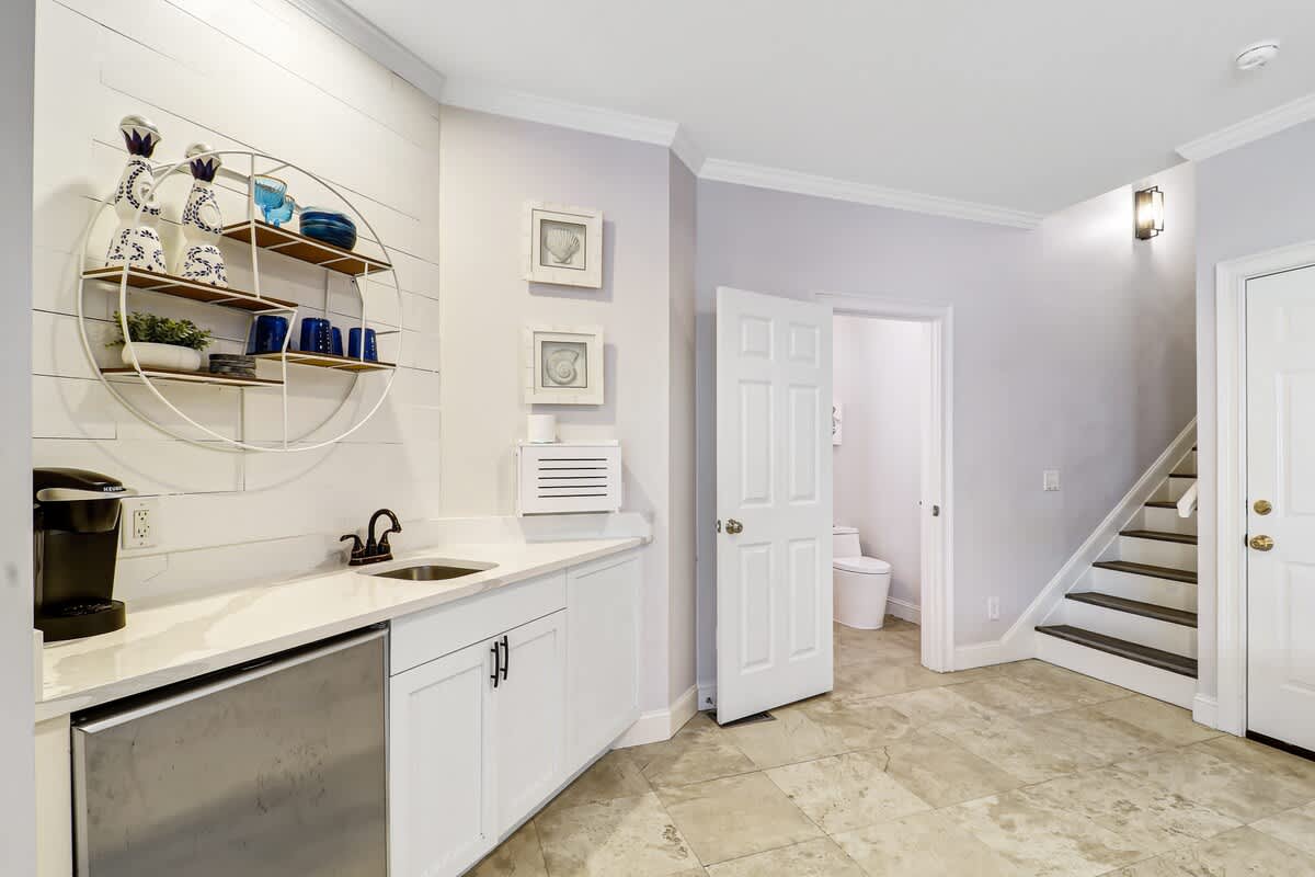 Your stylish wet bar features modern appliances and charming coastal-inspired decor, perfect for brewing morning coffee before exploring.