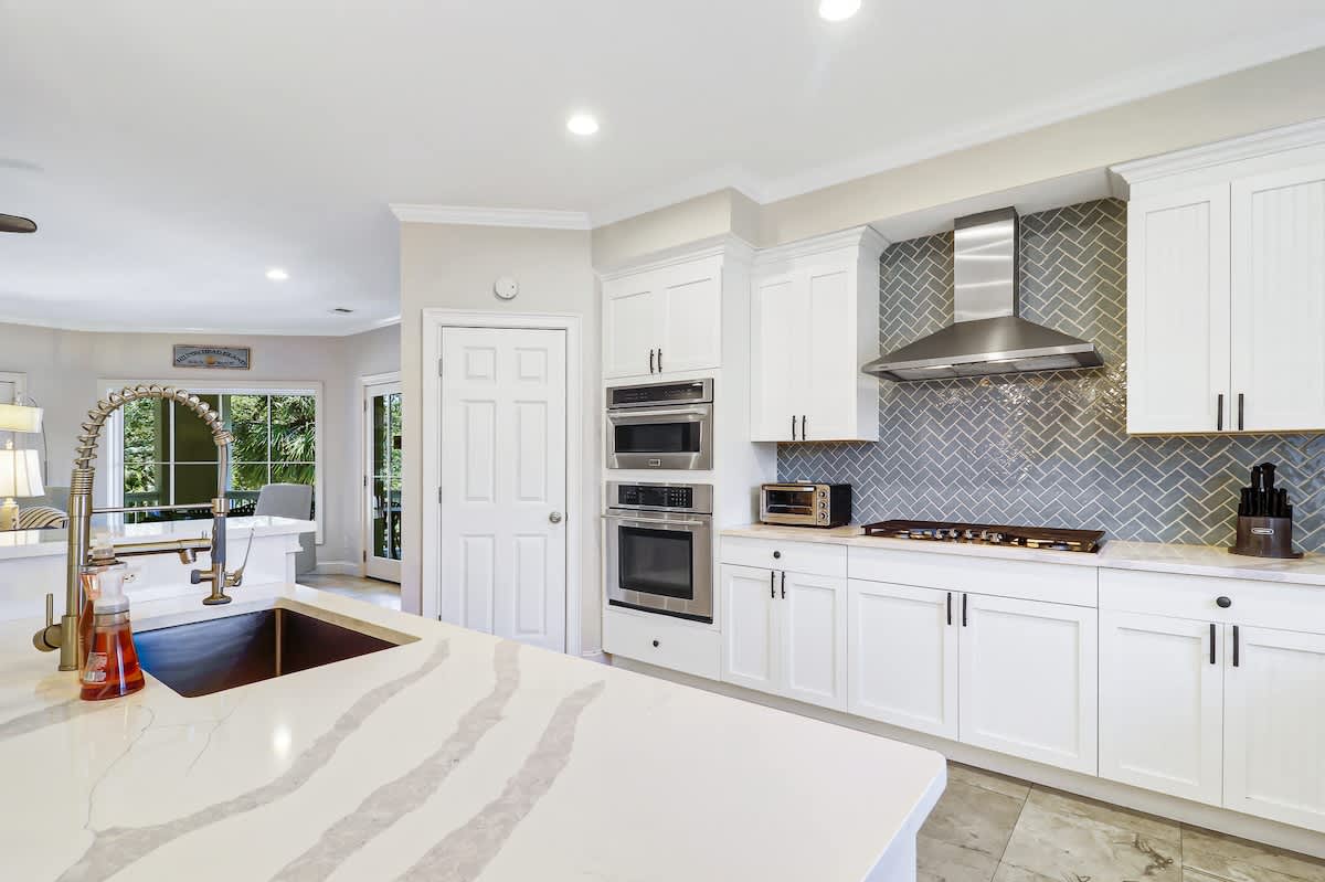 Cook up memorable meals in this gorgeous gourmet kitchen featuring marble countertops, stainless steel appliances, and elegant herringbone backsplash.