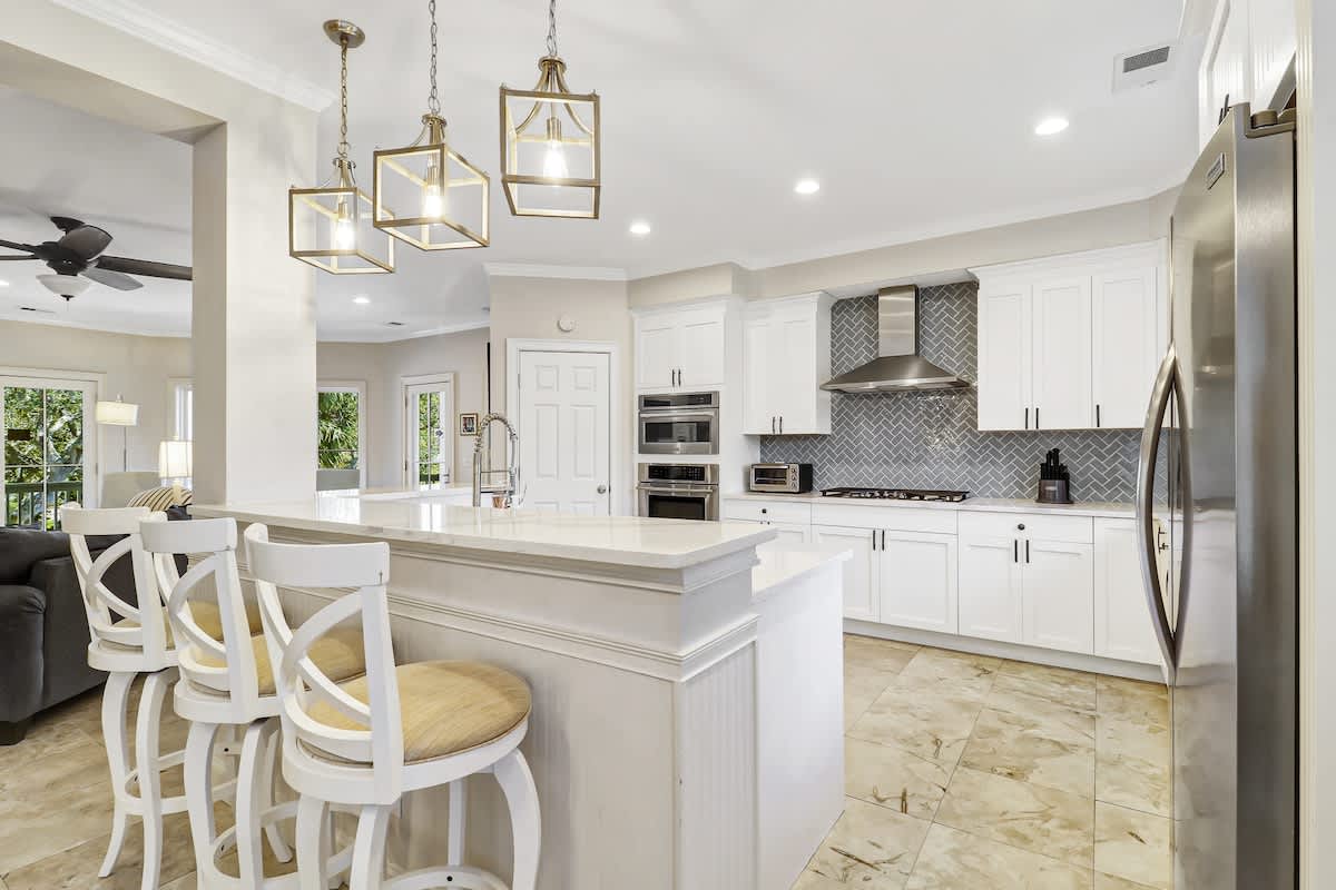 You'll love preparing meals in this bright, modern kitchen with white cabinetry, granite countertops, and stylish pendant lighting over the island.