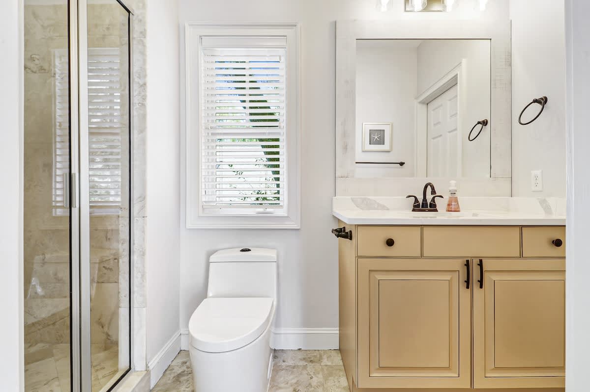 Step into your elegant bathroom sanctuary featuring marble finishes, a spacious glass shower, and warm wood vanity for ultimate comfort.