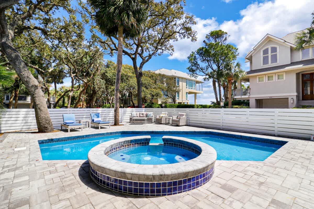 Dive into your private oasis with a sparkling pool and relaxing hot tub surrounded by comfortable lounge seating.