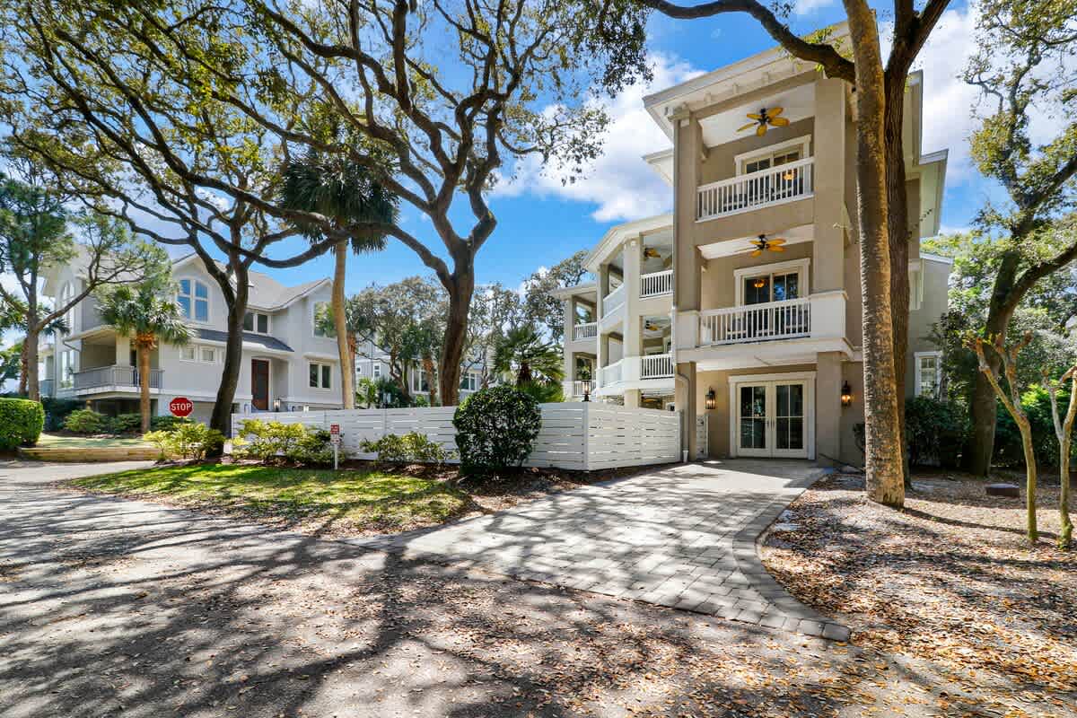 Modern beachside townhome with multiple balconies and tropical landscaping in a peaceful residential setting.
