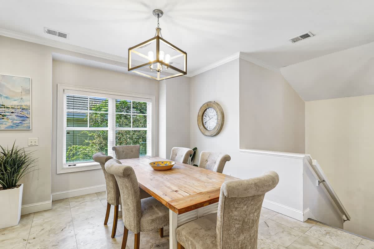 Your elegant dining space awaits memorable meals with warm wood tones and natural light streaming through large windows.