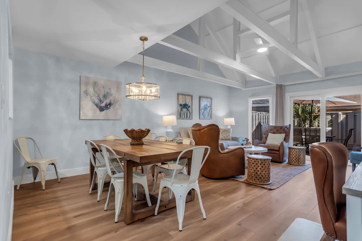 Gather around your spacious open-plan dining and living area, where exposed beams create character above comfortable leather seating and modern dining space.