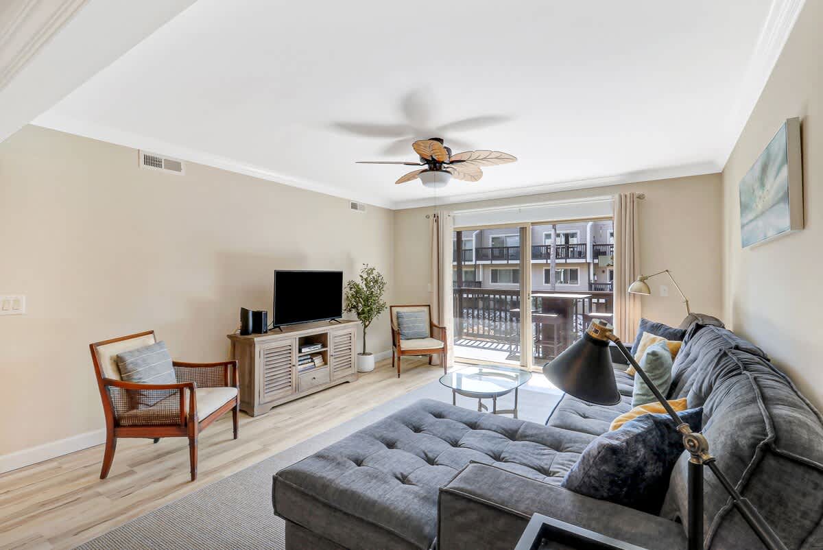 Unwind in your bright, modern living room with plush seating and natural light streaming through large windows.