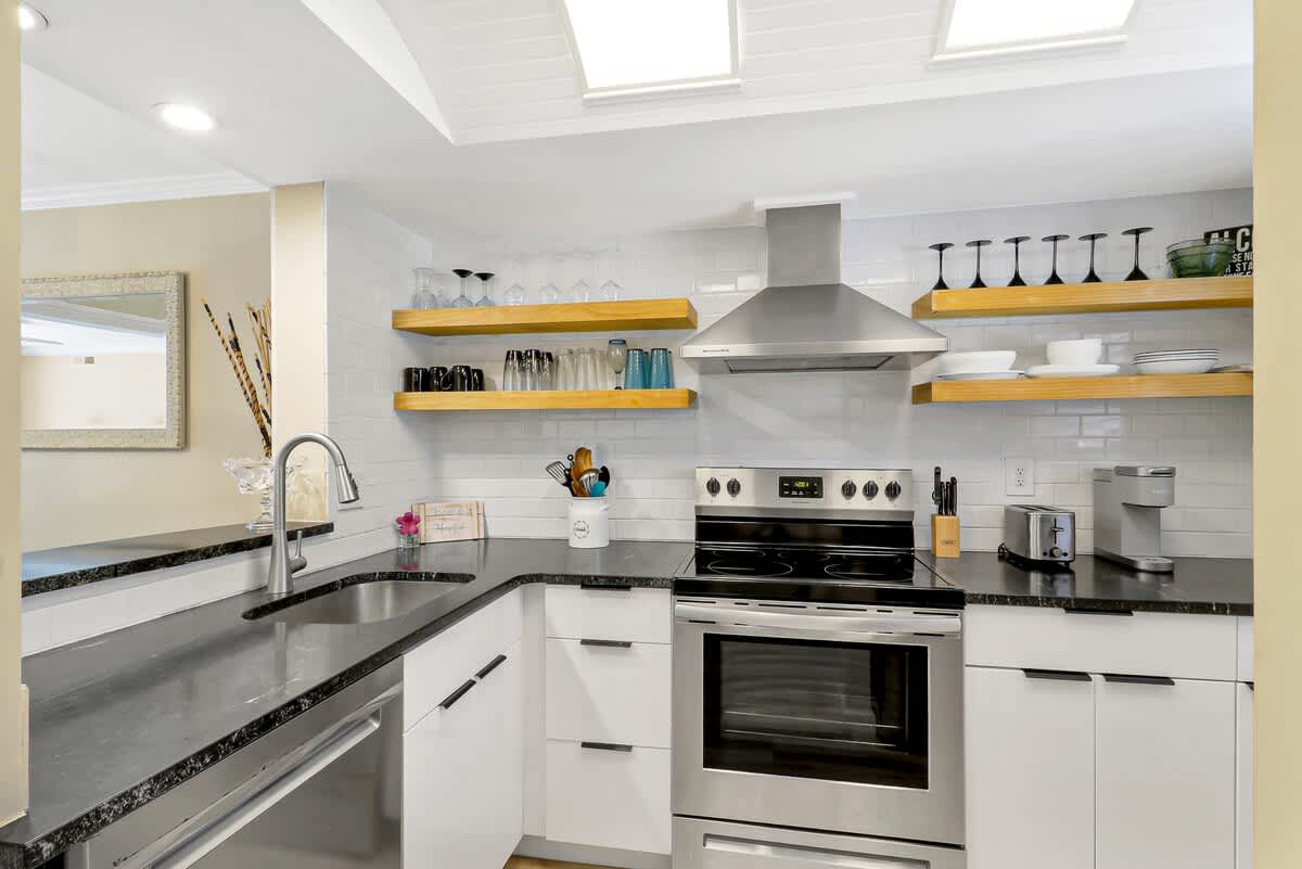 Your gourmet kitchen features sparkling countertops, modern appliances, and open shelving filled with everything you need for memorable meals.