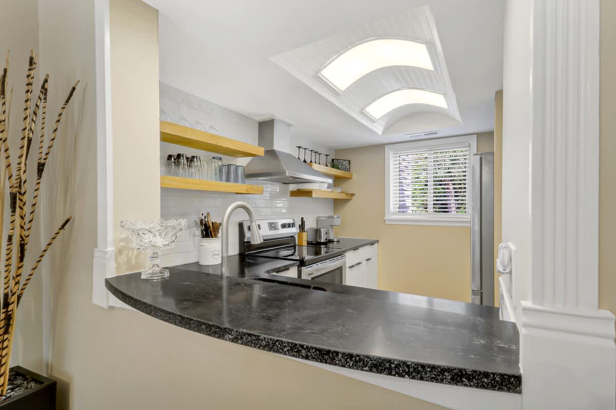 Your gourmet kitchen features sleek granite countertops, modern appliances, and gorgeous skylights that bathe your cooking space in natural light.