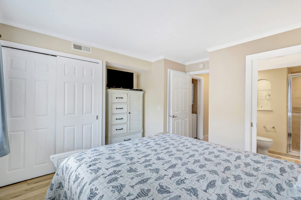 The comfortable primary bedroom offers ample storage, entertainment, and an en-suite bathroom steps away for ultimate convenience.