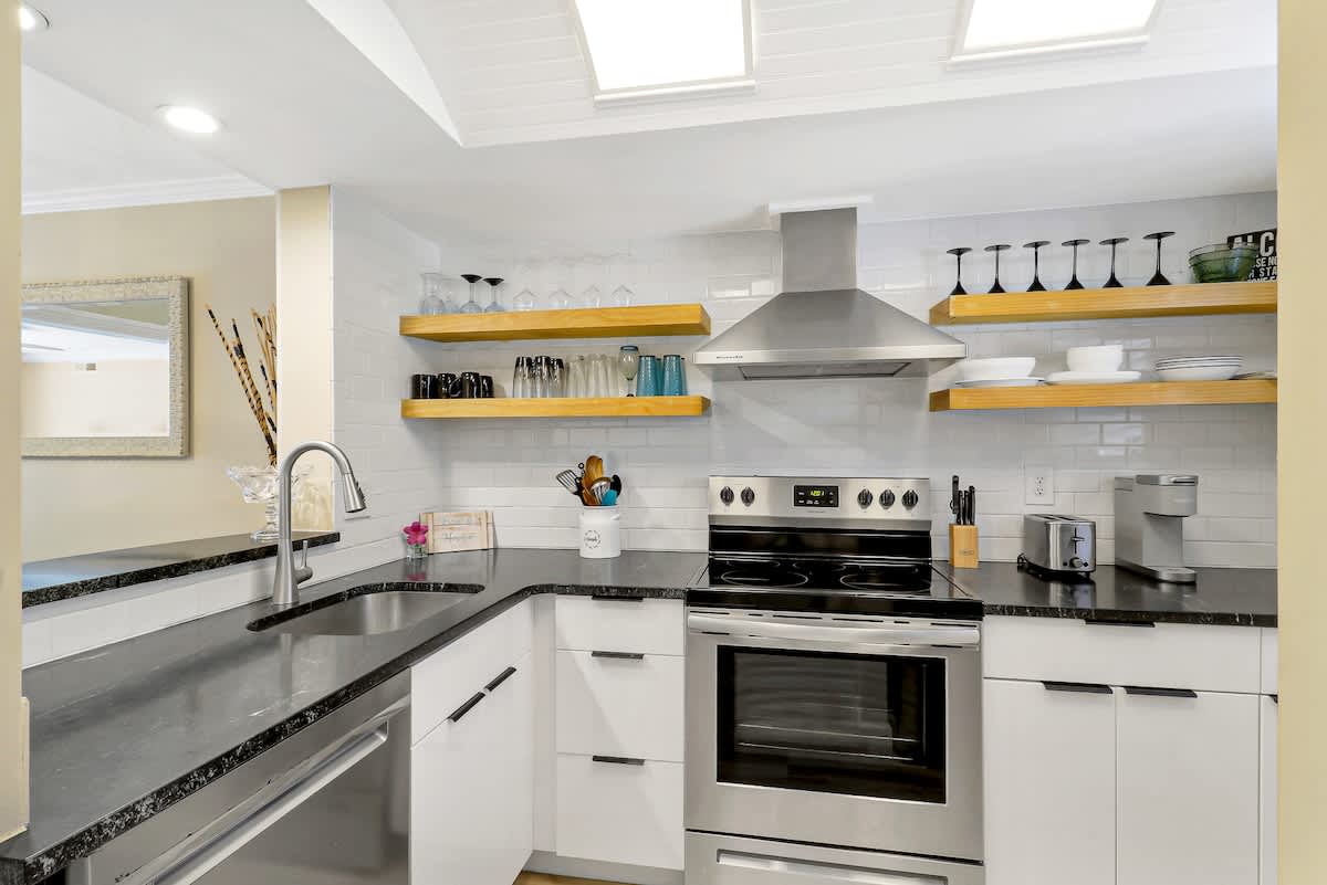 Your gourmet kitchen features sparkling countertops, modern appliances, and open shelving filled with everything you need for memorable meals.