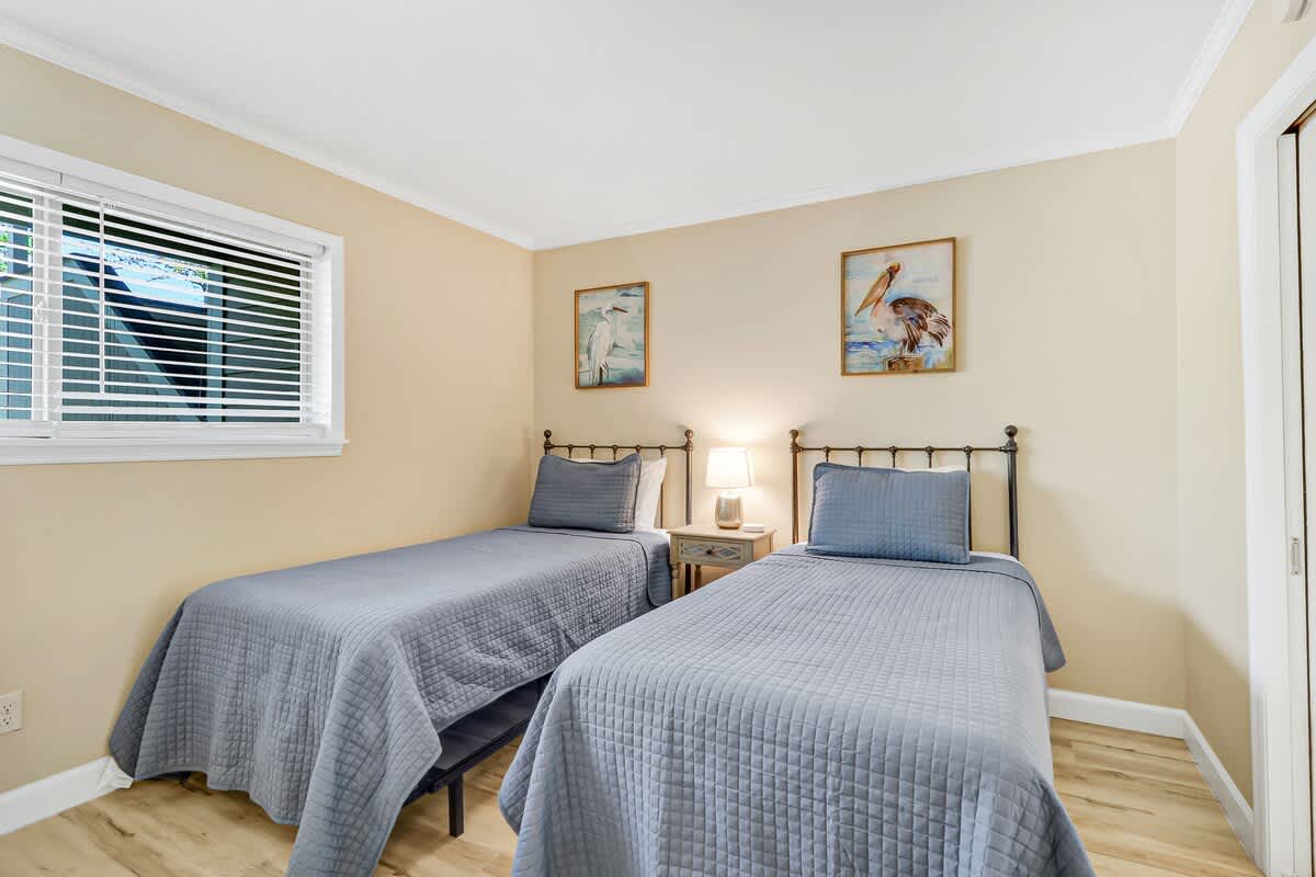Drift off peacefully in your cozy twin bedroom, where soft blue linens and gentle nautical artwork create the perfect seaside sanctuary.