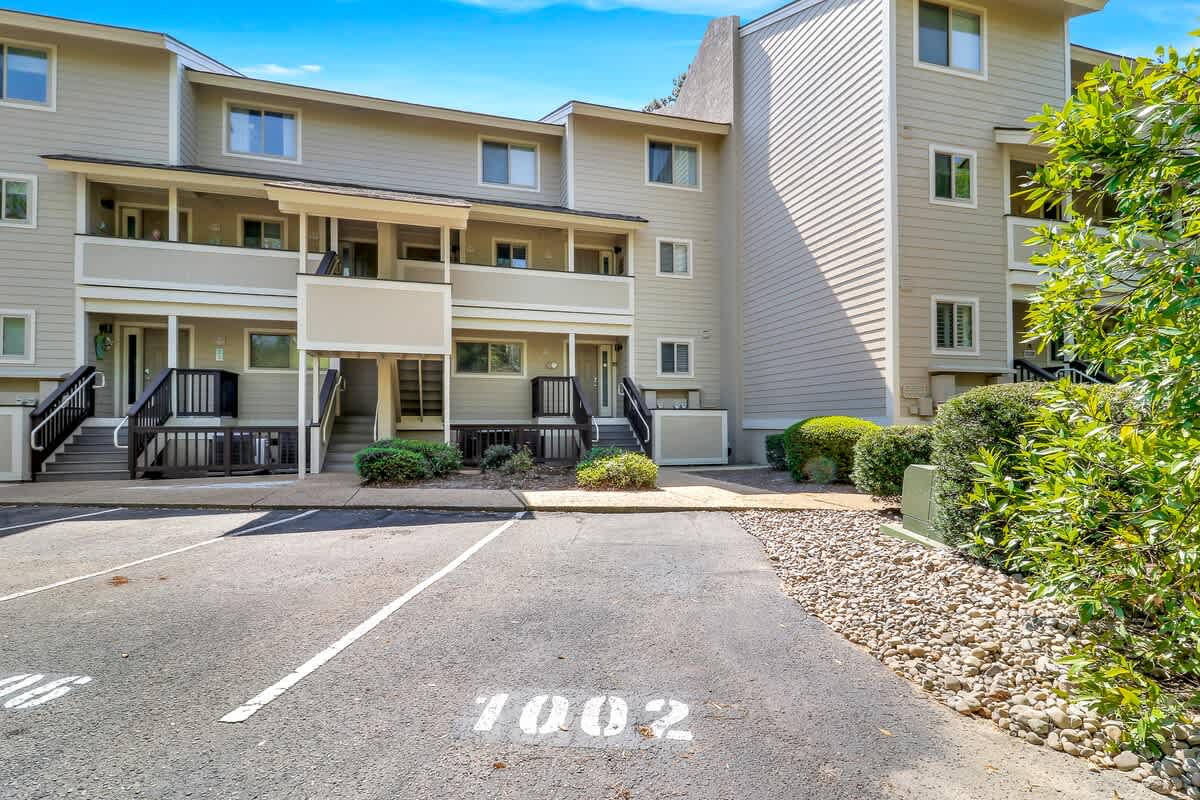 Modern vacation rental complex with numbered parking spaces and landscaped grounds providing a welcoming arrival experience.