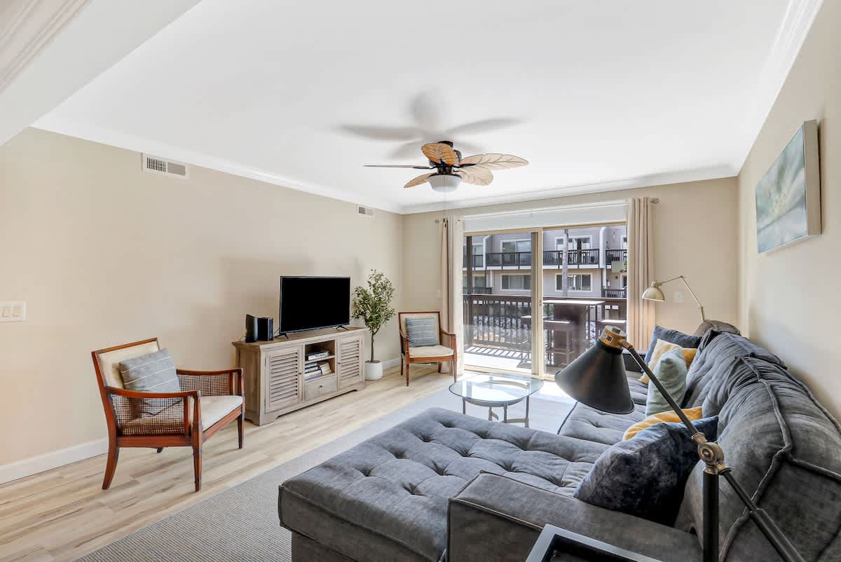 Unwind in your bright, modern living room with plush seating and natural light streaming through large windows.