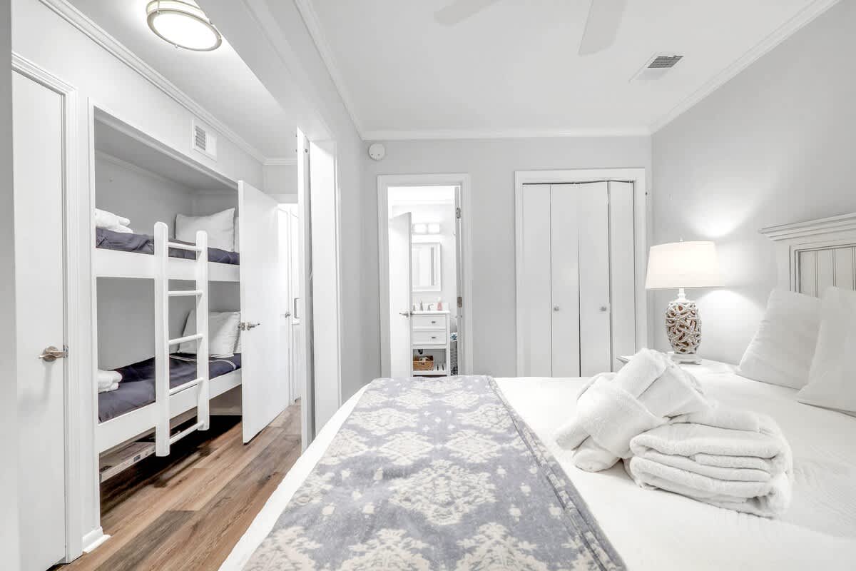 Primary Bedroom with Queen Bed and View of Bunk Beds in Hallway