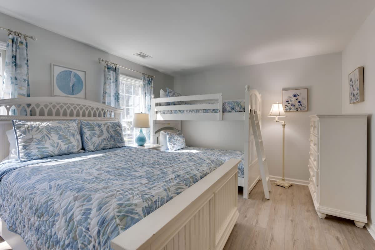 Your coastal-themed bedroom features a comfortable queen bed and cozy bunk bed, perfect for families seeking seaside tranquility.