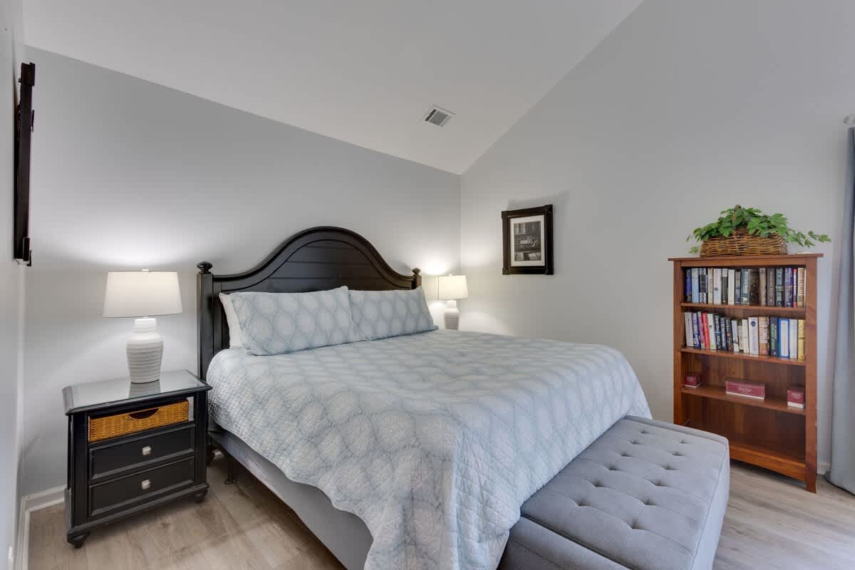 Your peaceful bedroom retreat features a plush bed with soft linens and a cozy reading nook with books nearby.