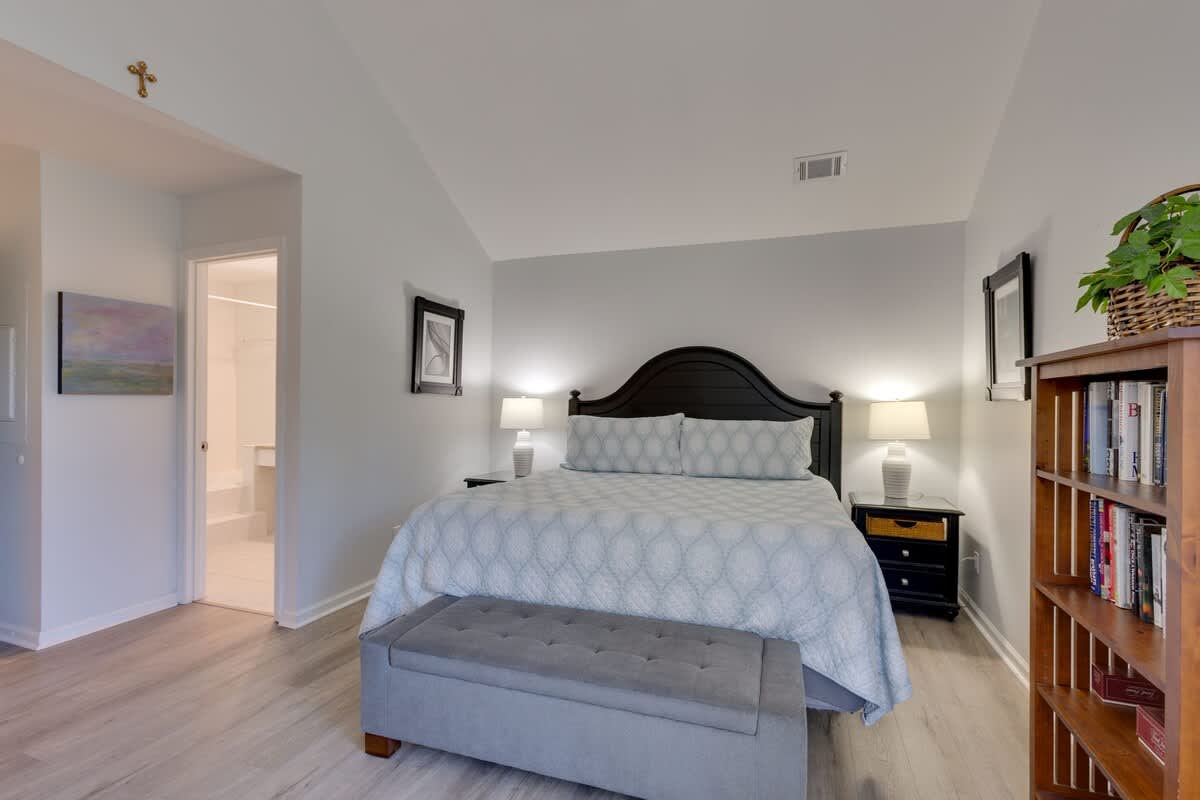 Unwind in your elegantly appointed bedroom with plush bedding, warm lighting, and a cozy reading nook filled with books for peaceful evenings.