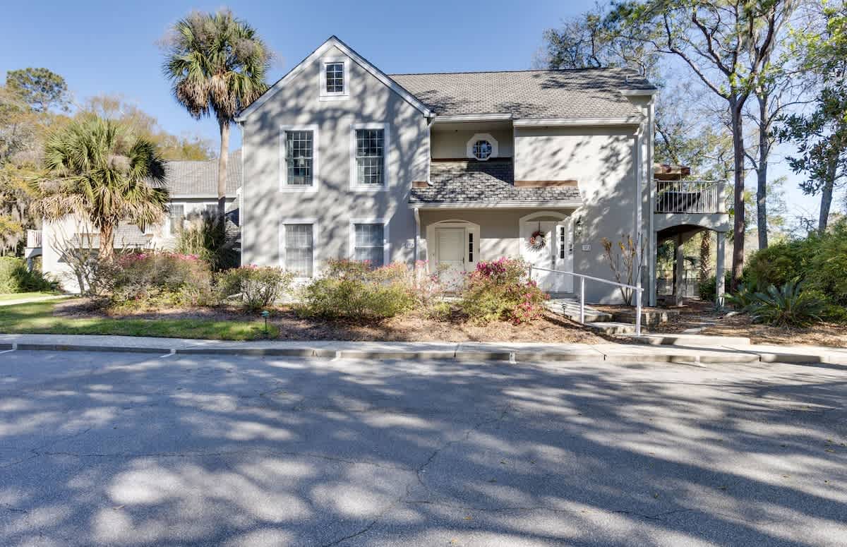 Charming coastal home with mature landscaping and palm trees in a peaceful neighborhood setting.