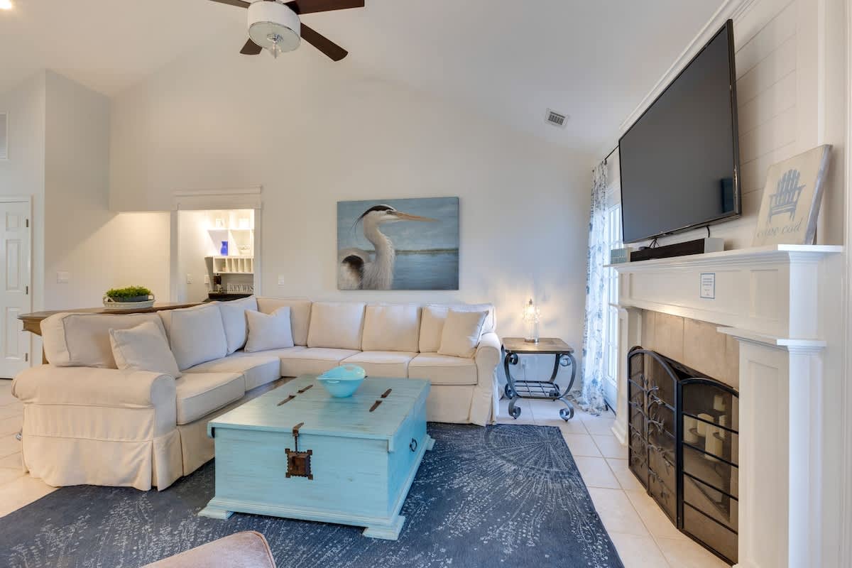 Sink into this coastal-inspired living room where soft whites meet ocean blues. Your perfect retreat features a fireplace for cozy evenings.