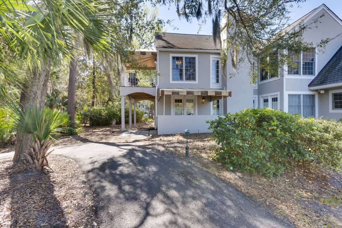 Charming coastal retreat nestled among mature palms and lush landscaping in a peaceful residential setting.