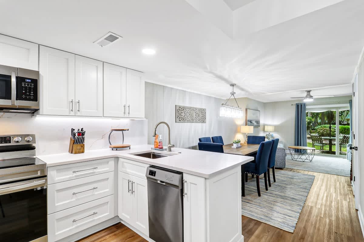 Step into your modern open-concept haven where crisp white cabinets and sleek appliances make cooking a joy.