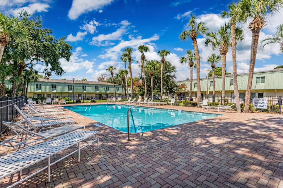 Sparkling pool surrounded by tropical palms and comfortable loungers—perfect for soaking up Florida sunshine during your stay.