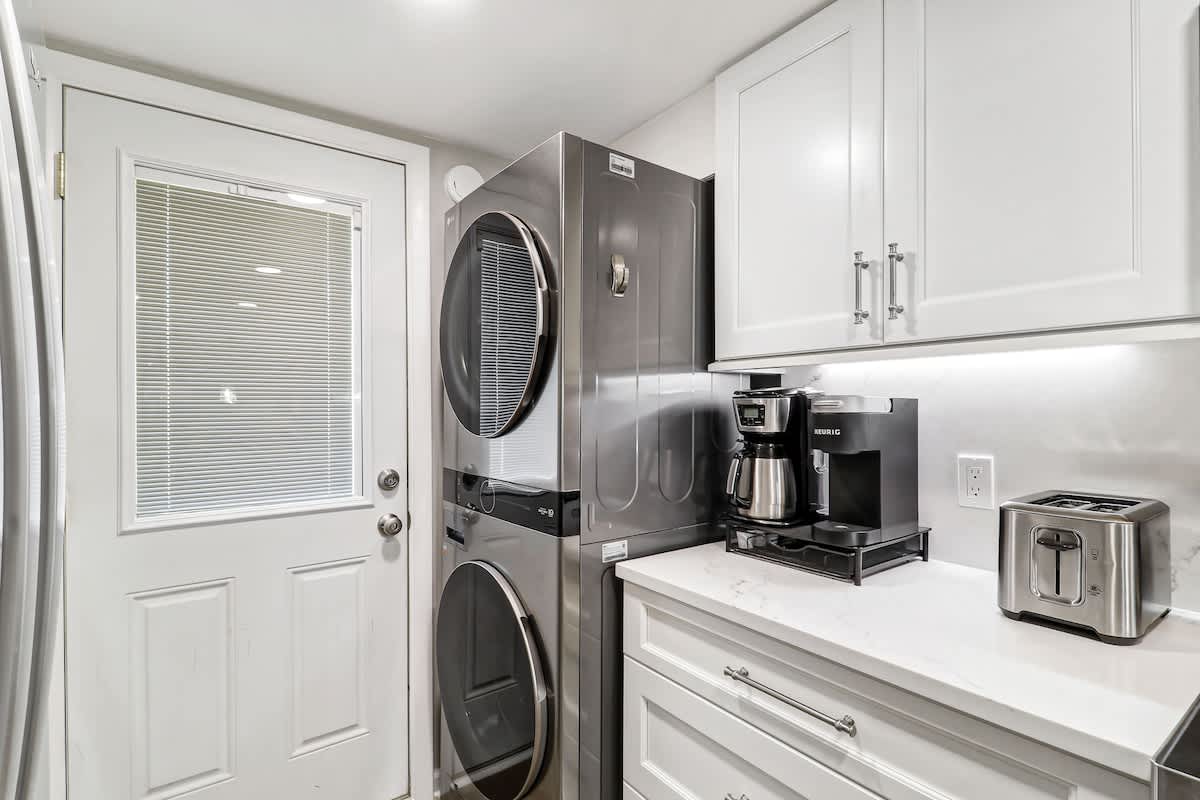 Convenient laundry corner features modern stacked machines.