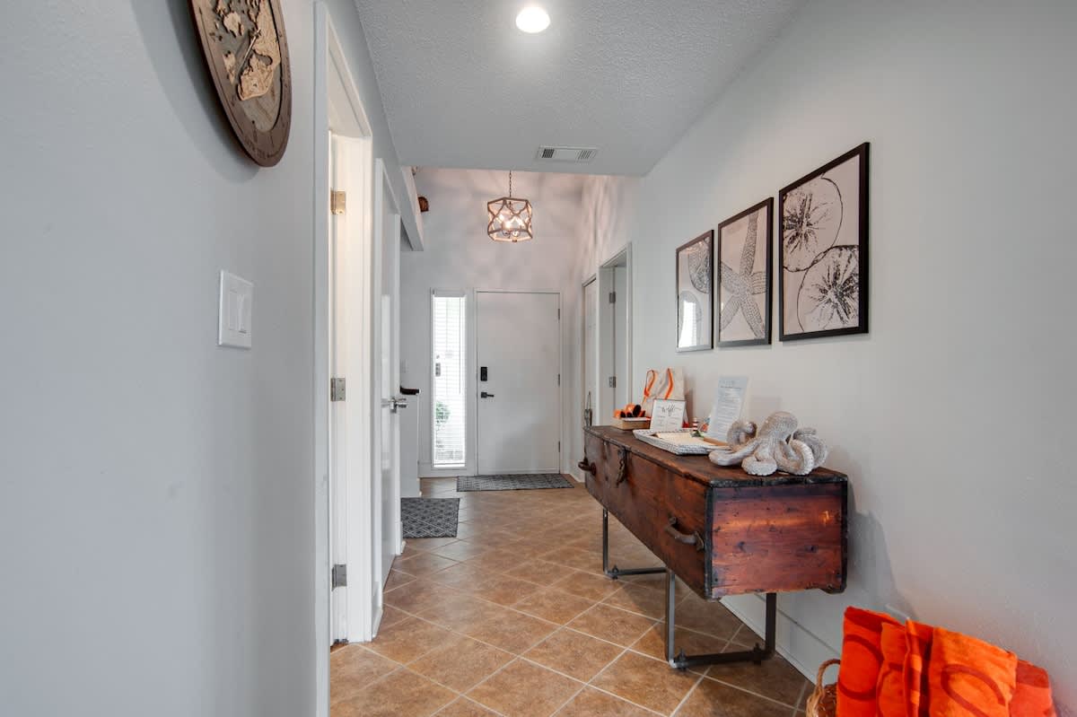 Step into your welcoming entryway where coastal art and vintage touches create an inviting first impression of your beach retreat.