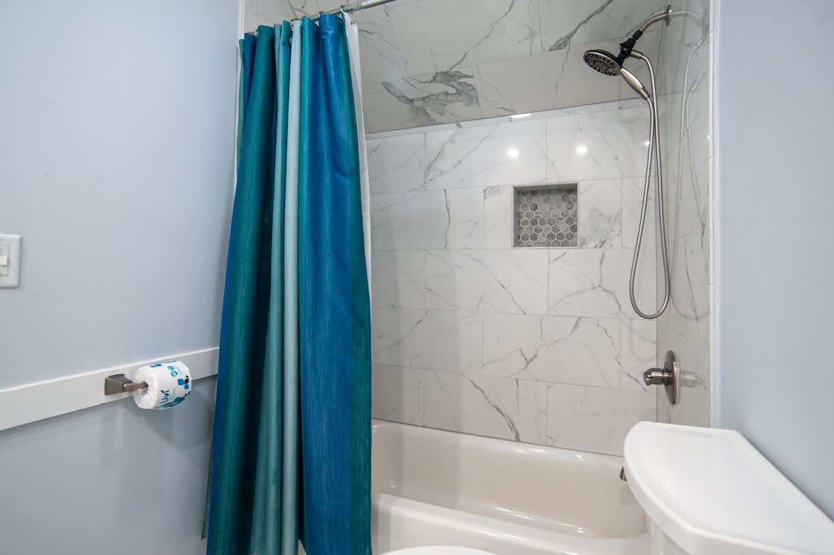 Refresh in your elegantly appointed bathroom featuring marble-inspired walls and a luxurious rainfall showerhead.