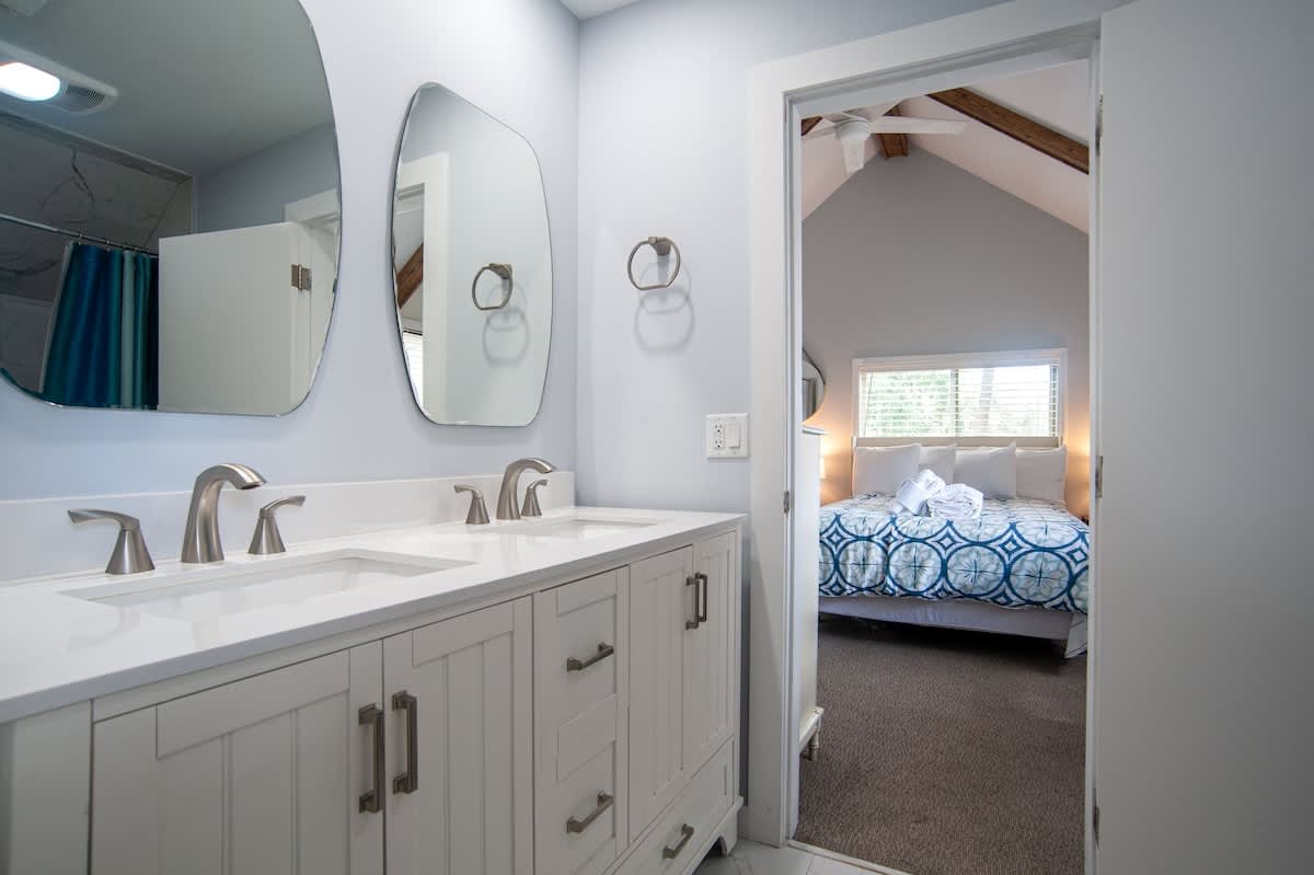 Fresh towels await in your stylish bathroom, perfectly positioned between restful spaces for ultimate convenience.