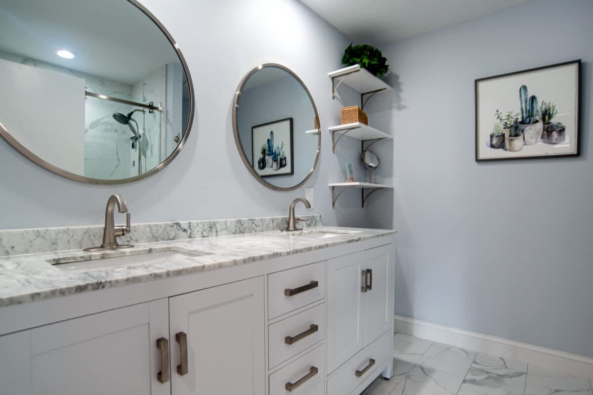 Step into your elegant bathroom with dual vanities, marble countertops, and thoughtful shelving for all your essentials.