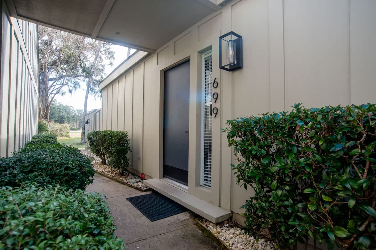 Modern property entrance with landscaped gardens and clear unit numbering for easy arrival identification.