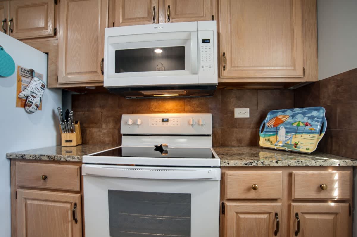 Cook your favorite meals in this fully equipped kitchen with modern appliances and granite countertops.