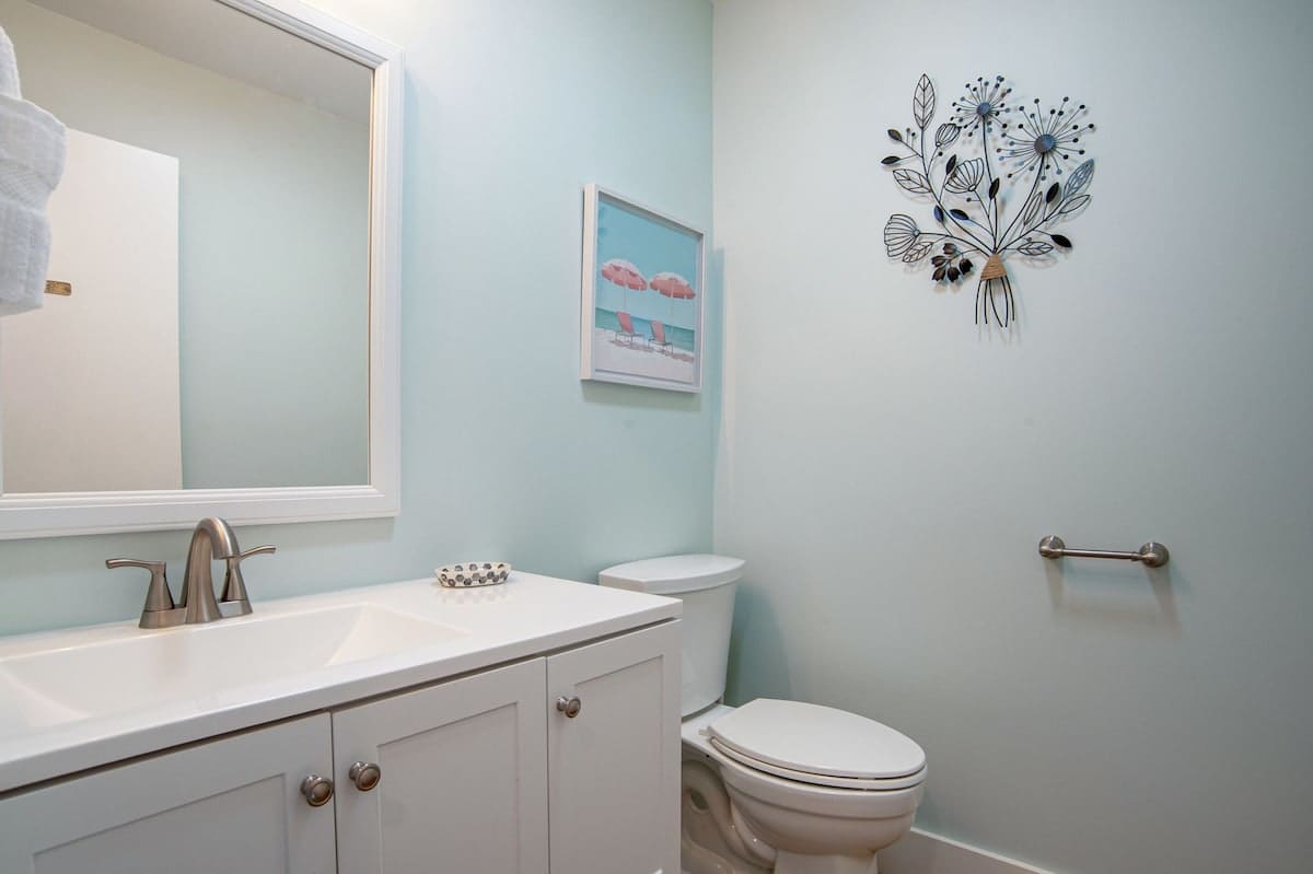 Refresh in this peaceful powder room with soothing mint walls, elegant white fixtures, and thoughtful coastal touches.