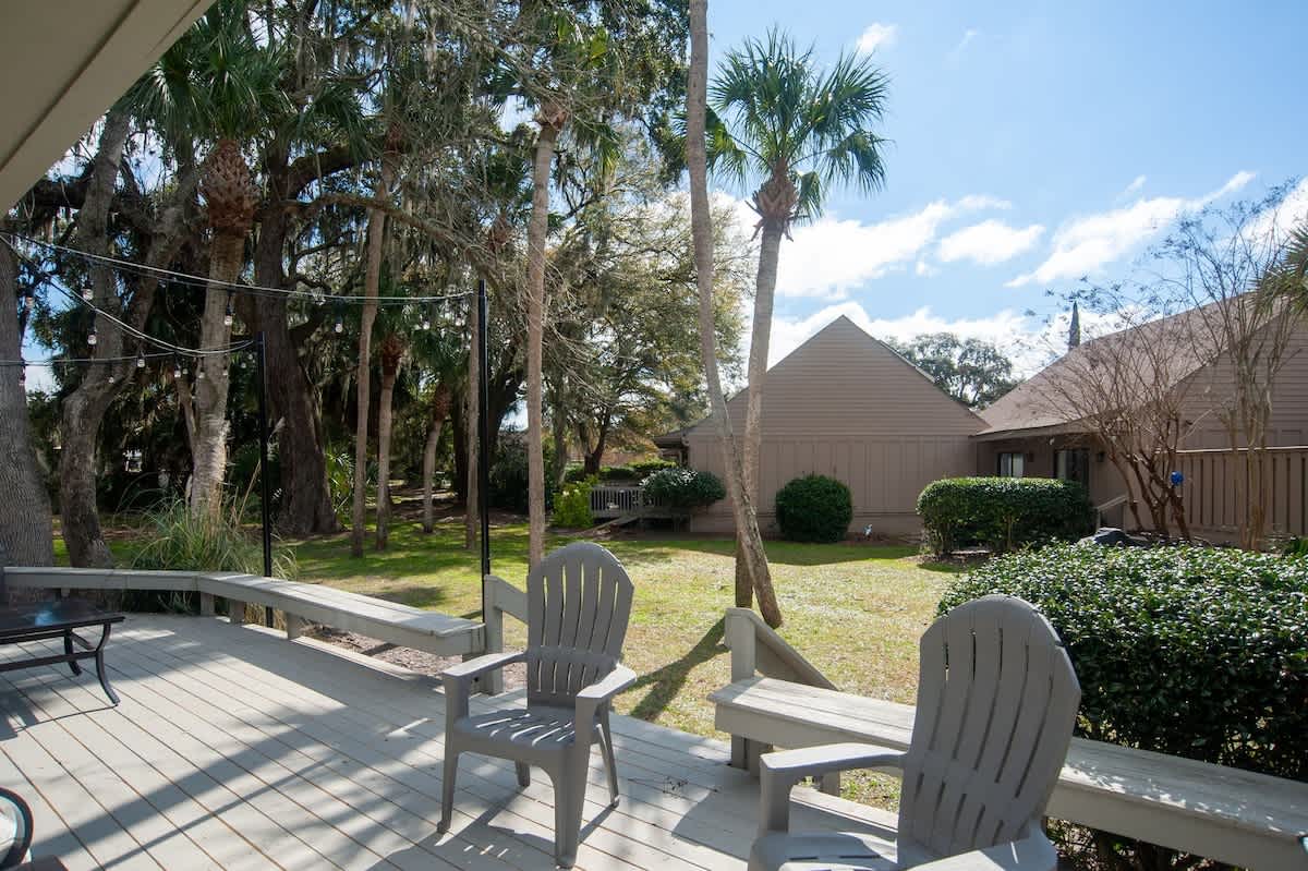 Your private deck offers peaceful garden views where you can unwind in comfortable chairs surrounded by lush tropical landscaping.