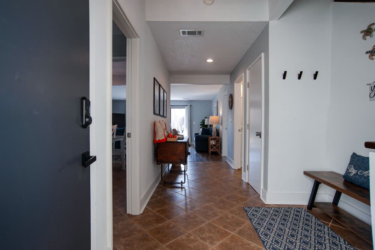 Step into your welcoming entrance hallway where coastal blues and warm wood create an inviting arrival experience.