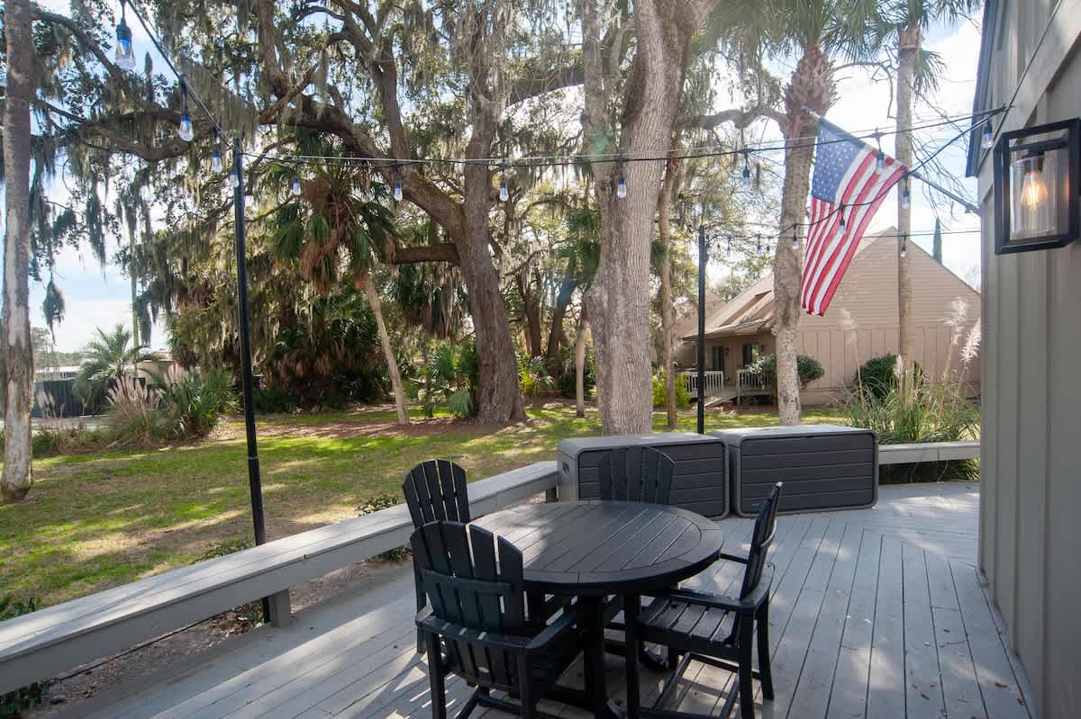 Your private deck offers peaceful outdoor dining surrounded by mature oak trees and a charming neighborhood setting.