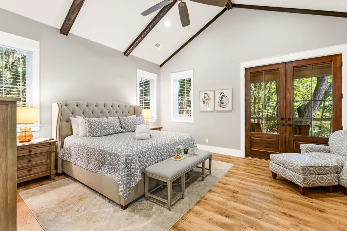 Primary Suite on First Floor with King Bed, En-Suite Bathroom, and Access to Wraparound Porch
