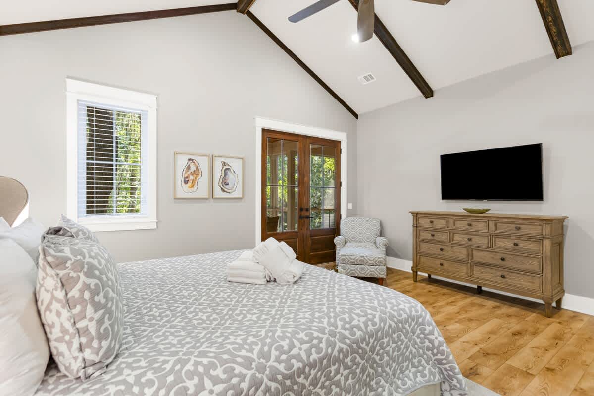 Primary Suite on First Floor with King Bed, En-Suite Bathroom, and Access to Wraparound Porch
