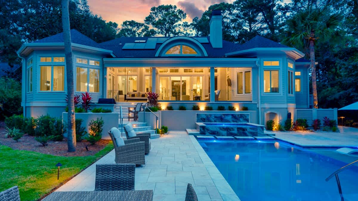 Luxurious Private Backyard with Pool, Ample Seating, and Screened in Porch at Sunset