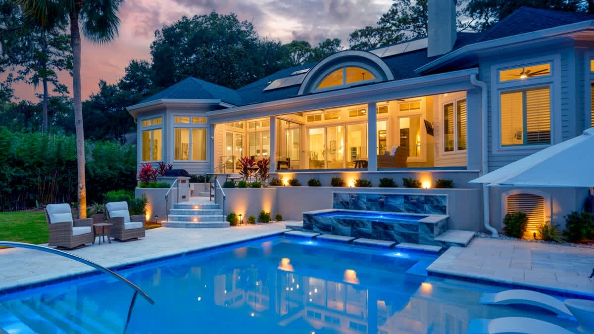 Luxurious Private Backyard with Pool, Ample Seating, and Screened in Porch at Sunset