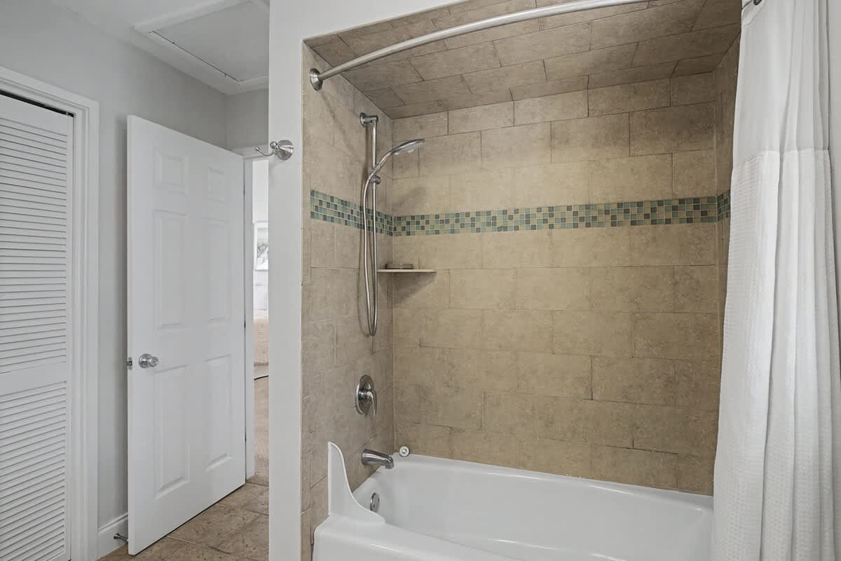 Your private bathroom features elegant stone-look tile and modern fixtures for a spa-like shower and bath experience.