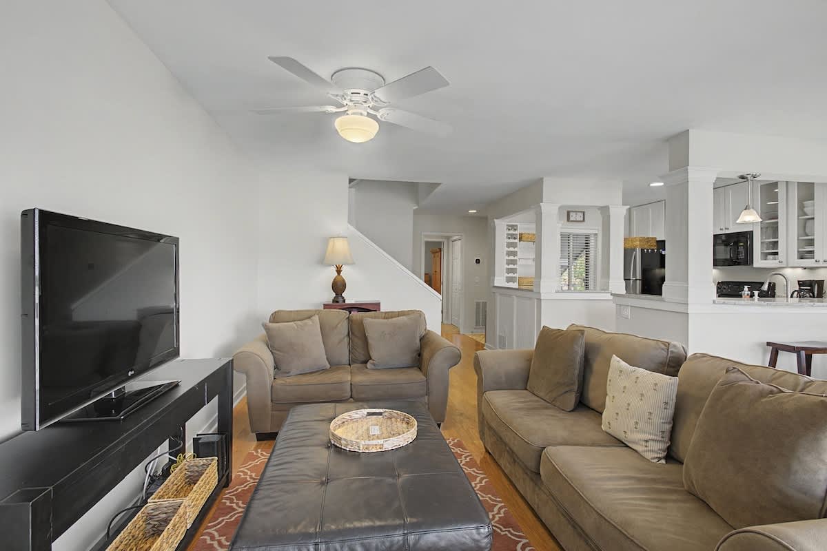 Relax in your spacious living room with plush seating, entertainment center, and open flow to the kitchen.