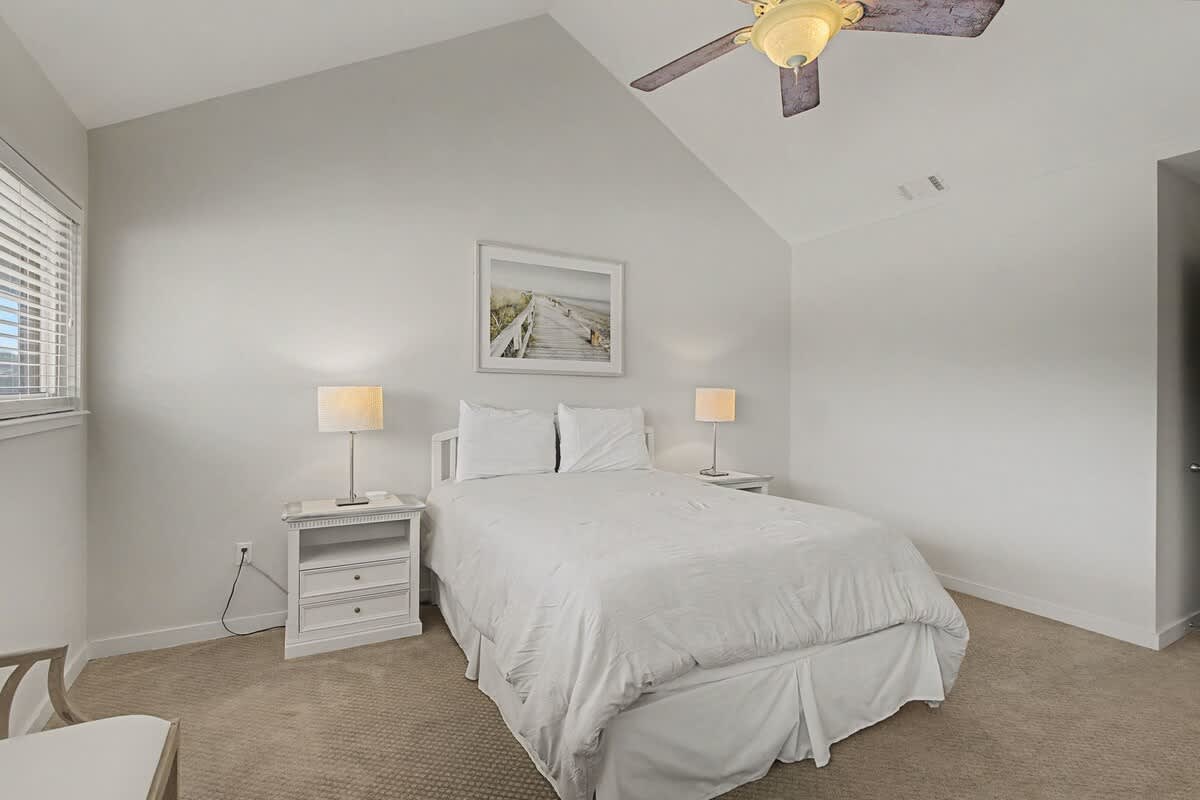 Drift off to peaceful sleep in your serene bedroom, complete with plush white linens and gentle bedside lighting for ultimate comfort.