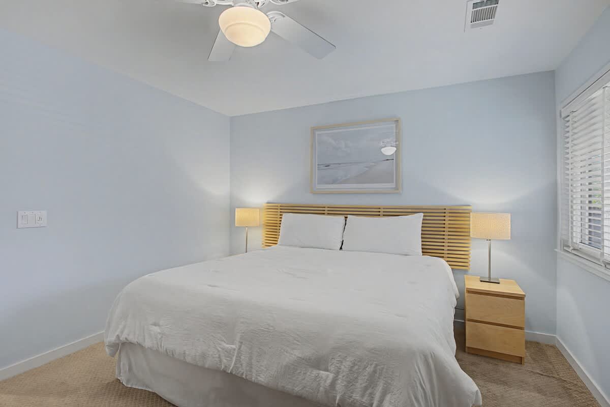 Drift off in your serene bedroom with plush bedding, gentle lighting, and calming coastal artwork creating the perfect restful retreat.