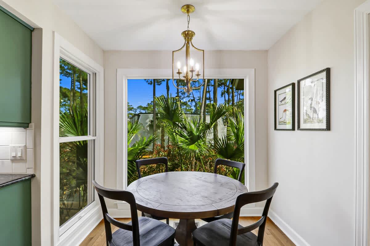 Enjoy intimate meals at your elegant round table, surrounded by tropical garden views through floor-to-ceiling windows that fill the space with natural light.